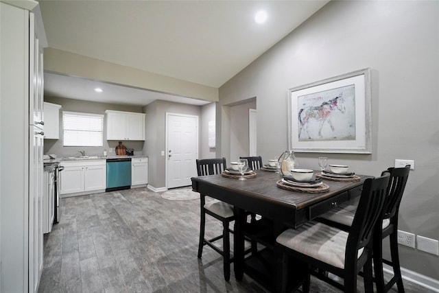 dining area featuring lofted ceiling, baseboards, wood finished floors, and recessed lighting