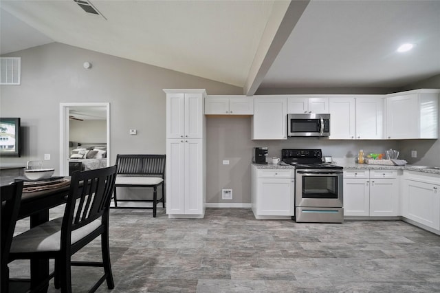 kitchen featuring appliances with stainless steel finishes, lofted ceiling, white cabinets, and visible vents