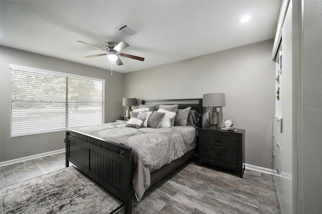 bedroom featuring baseboards, visible vents, ceiling fan, and wood finished floors