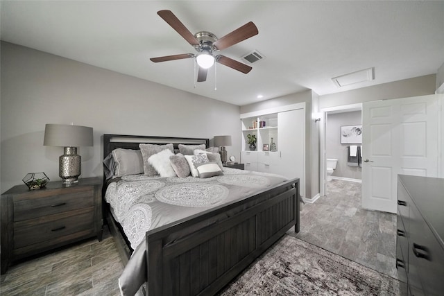 bedroom with a ceiling fan, baseboards, visible vents, light wood-type flooring, and attic access