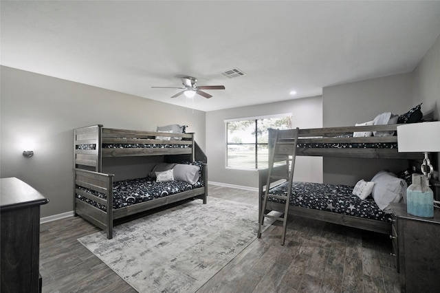 bedroom with ceiling fan, wood finished floors, visible vents, and baseboards