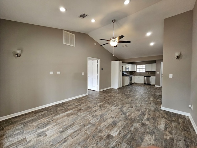 unfurnished living room with dark wood-style flooring, visible vents, a ceiling fan, vaulted ceiling, and baseboards