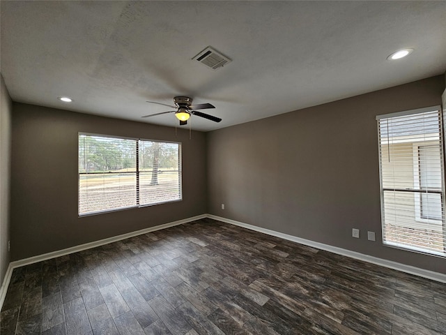 spare room featuring baseboards, visible vents, and dark wood-type flooring