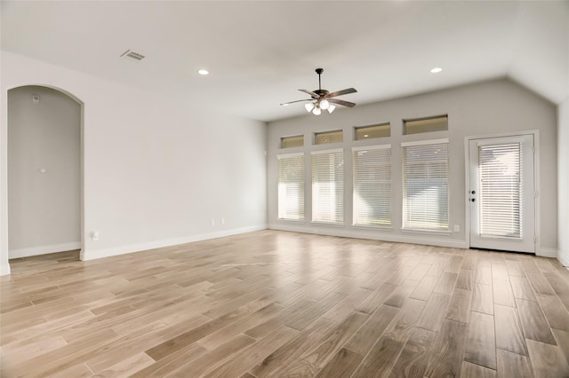 unfurnished living room with light wood-type flooring, arched walkways, visible vents, and ceiling fan