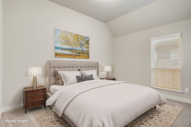 bedroom with lofted ceiling, light colored carpet, and baseboards