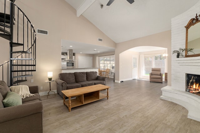 living room with baseboards, visible vents, wood finished floors, stairs, and a fireplace