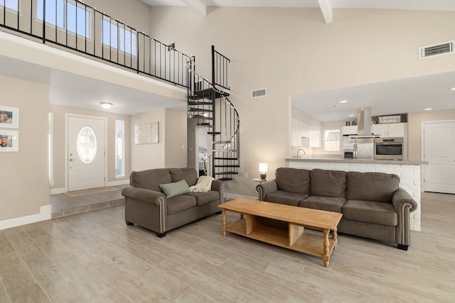 living area with visible vents, light wood-style flooring, and stairs