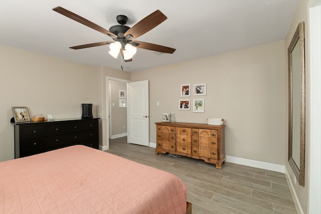 bedroom featuring light wood-style floors, baseboards, and a ceiling fan