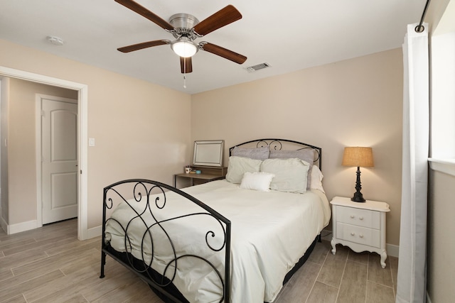 bedroom with wood tiled floor, visible vents, ceiling fan, and baseboards