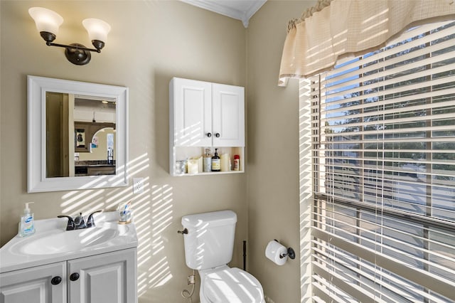 half bathroom with toilet, crown molding, and vanity