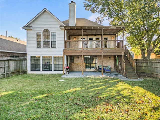 rear view of house with a patio, a lawn, a chimney, and a fenced backyard