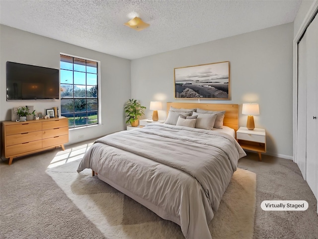 bedroom featuring a closet, carpet flooring, a textured ceiling, and baseboards