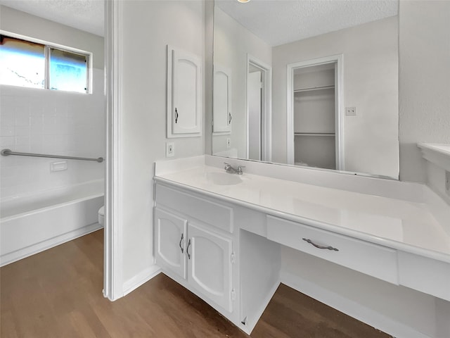 full bath featuring a textured ceiling, vanity, and wood finished floors