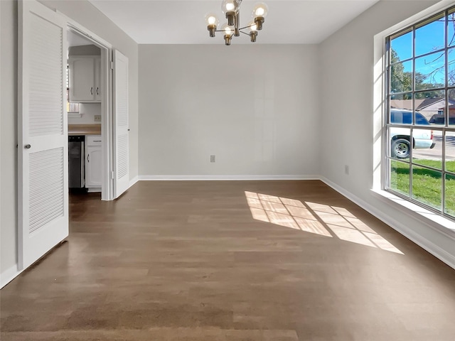 unfurnished dining area with plenty of natural light, baseboards, dark wood finished floors, and a notable chandelier