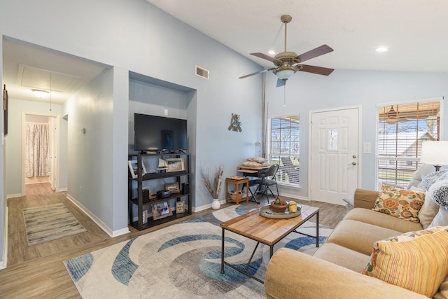 living room featuring ceiling fan, wood finished floors, visible vents, baseboards, and attic access