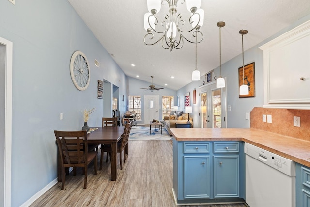 kitchen featuring dishwasher, a peninsula, vaulted ceiling, blue cabinetry, and backsplash