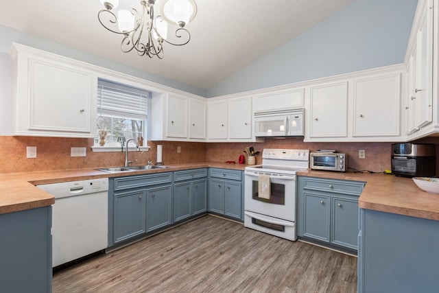 kitchen featuring white appliances, a sink, white cabinets, and blue cabinets