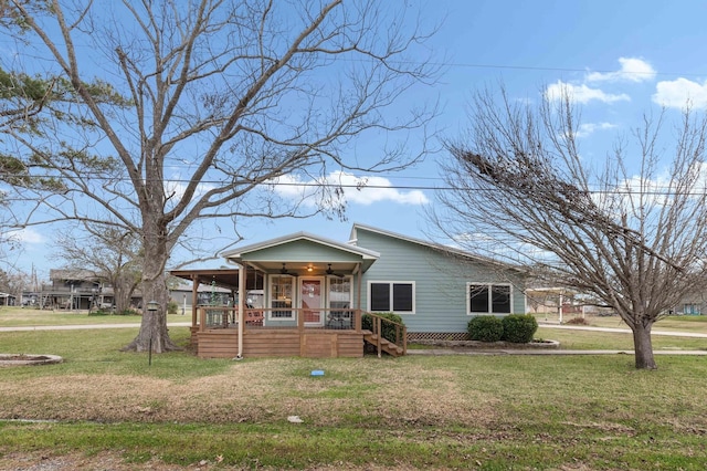 view of front of house with ceiling fan and a front lawn