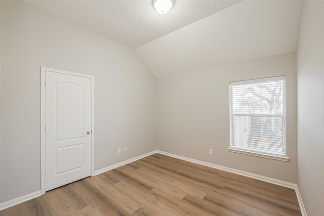 additional living space with vaulted ceiling, light wood-style flooring, and baseboards