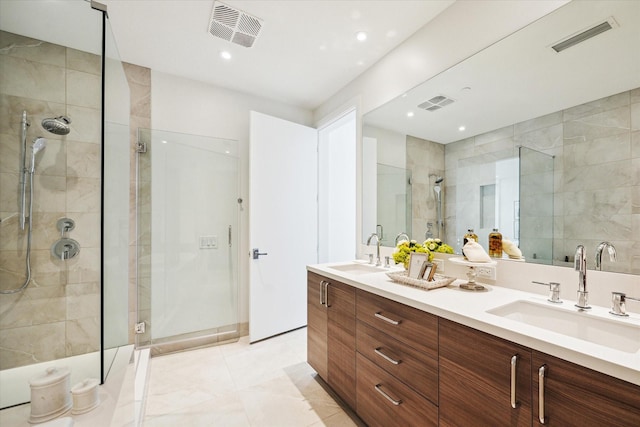 bathroom featuring visible vents, a sink, and a shower stall