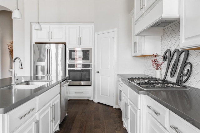 kitchen with arched walkways, stainless steel appliances, dark wood-type flooring, a sink, and custom range hood