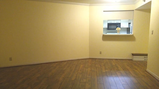 unfurnished room featuring ornamental molding, baseboards, and dark wood-style floors