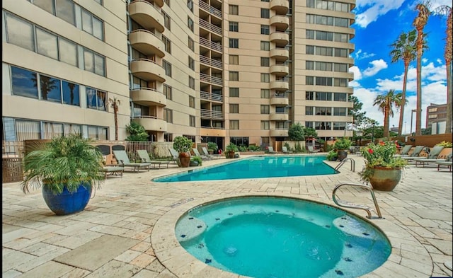 community pool with a community hot tub and a patio