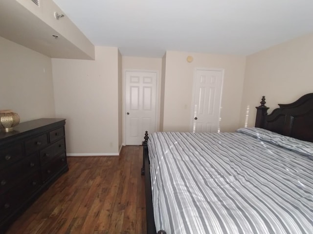 bedroom with dark wood-style floors and baseboards