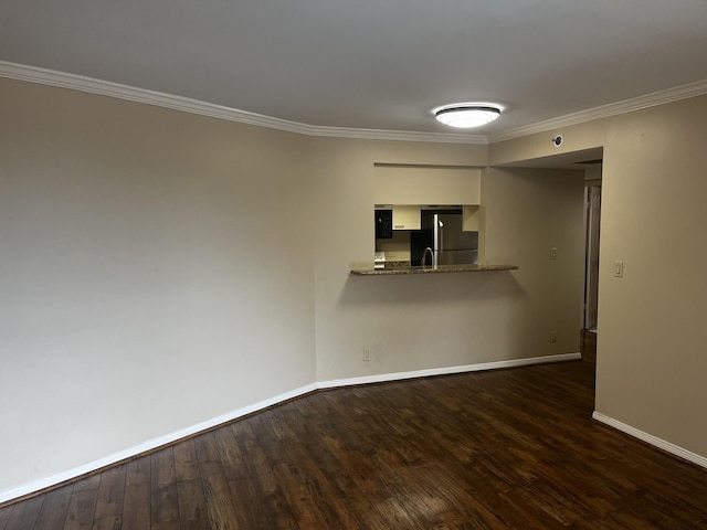empty room featuring baseboards, ornamental molding, and dark wood-style flooring