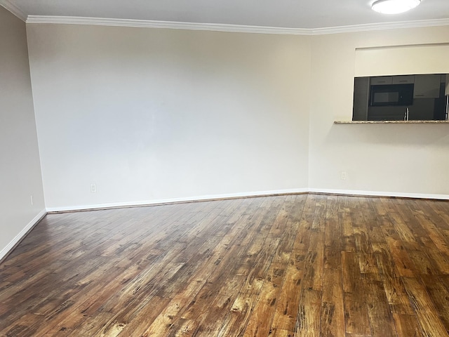 unfurnished room with wood-type flooring, baseboards, and crown molding