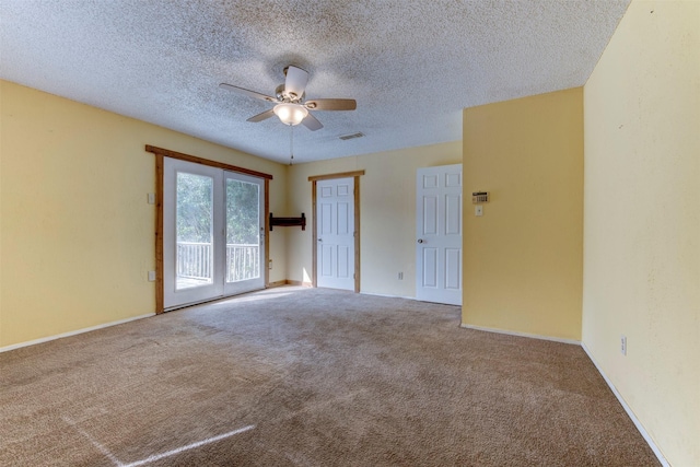 carpeted empty room featuring ceiling fan, a textured ceiling, visible vents, and baseboards