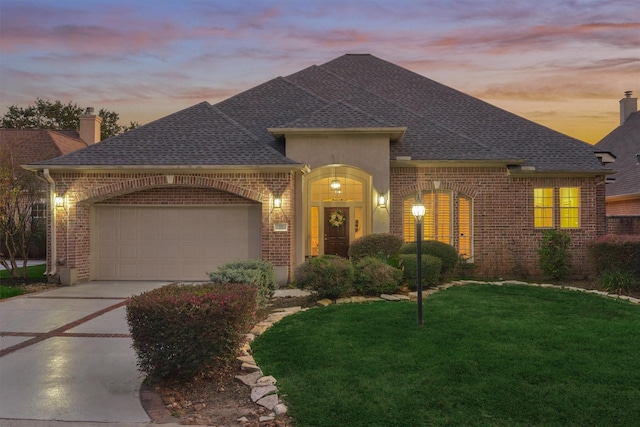 view of front of home featuring concrete driveway, brick siding, a front lawn, and a shingled roof