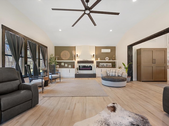 living area with light wood finished floors, recessed lighting, ceiling fan, a wall mounted air conditioner, and a glass covered fireplace