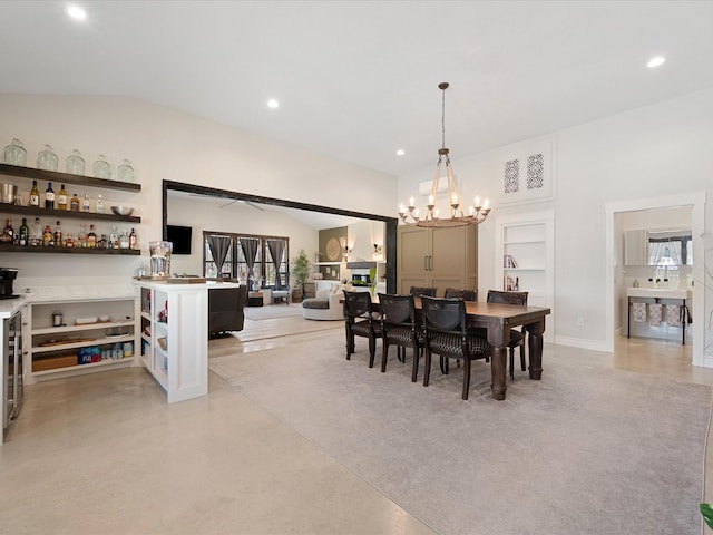 dining space featuring a notable chandelier, recessed lighting, concrete flooring, and vaulted ceiling