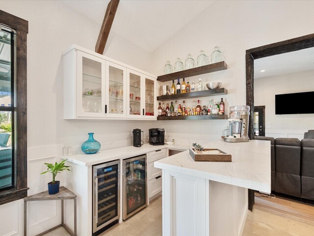 bar featuring wine cooler, a dry bar, and lofted ceiling