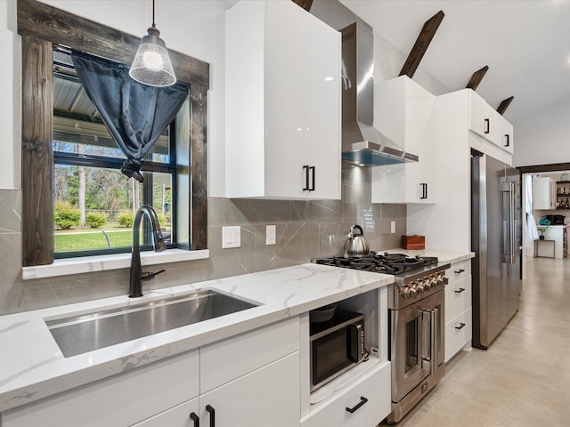 kitchen with a sink, pendant lighting, white cabinetry, wall chimney range hood, and high quality appliances