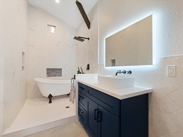 full bath with lofted ceiling, a soaking tub, tile walls, and vanity