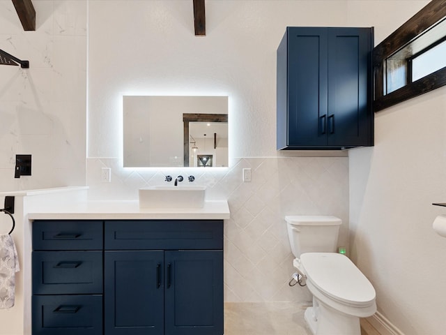 bathroom with vanity, tile walls, toilet, and tasteful backsplash