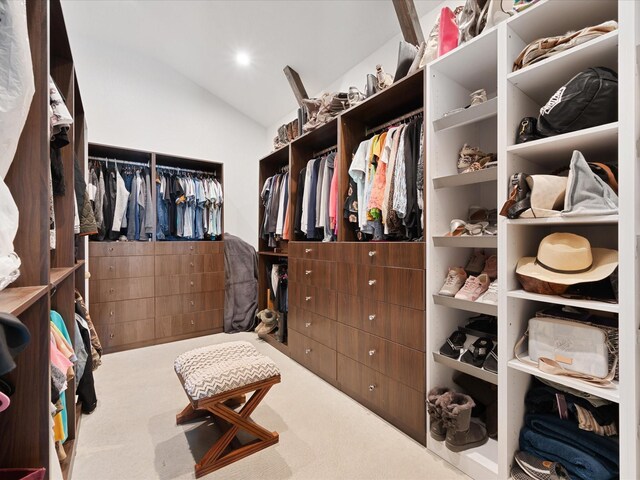 walk in closet featuring carpet flooring and lofted ceiling