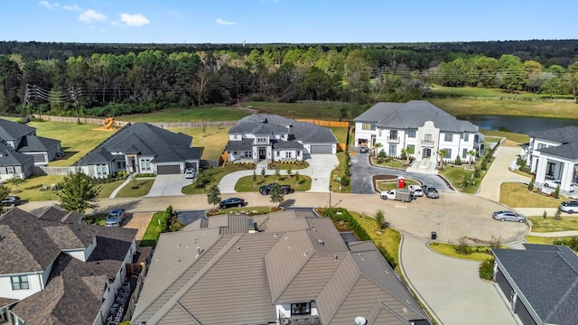 drone / aerial view with a residential view, a water view, and a wooded view