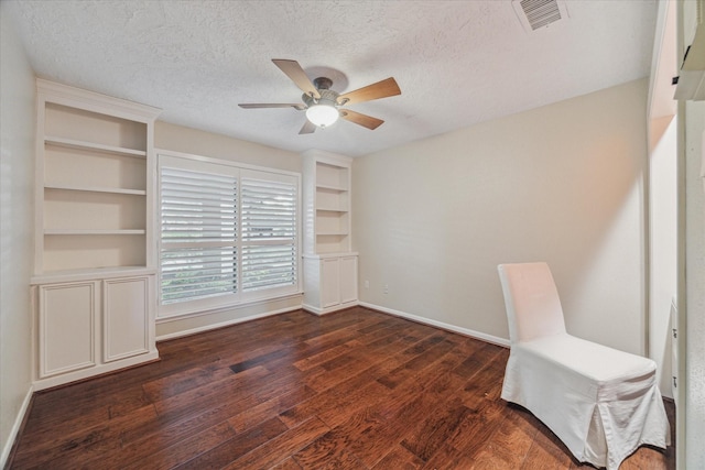 interior space with baseboards, visible vents, dark wood finished floors, ceiling fan, and a textured ceiling