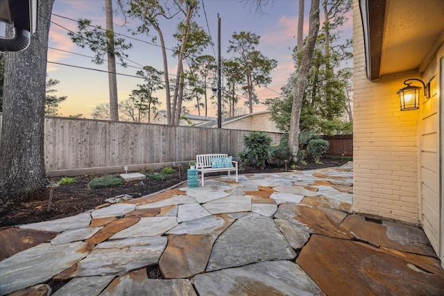 patio terrace at dusk with a fenced backyard