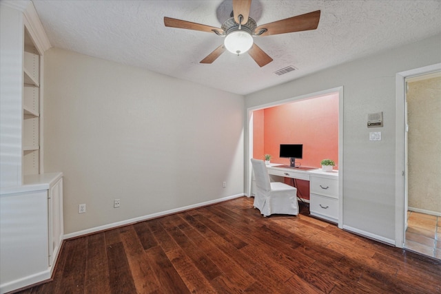 unfurnished office with a textured ceiling, wood finished floors, visible vents, and baseboards