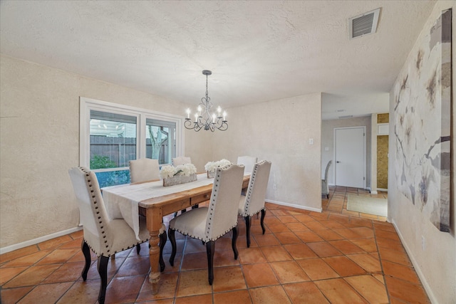 dining room with visible vents, a textured wall, an inviting chandelier, light tile patterned flooring, and a textured ceiling