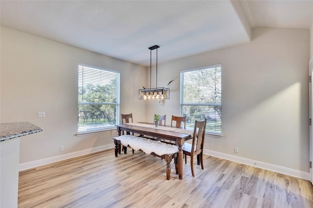 dining room with light wood finished floors, plenty of natural light, and baseboards