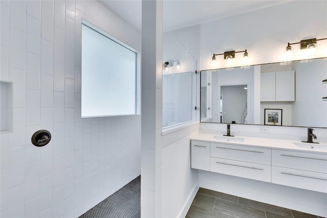 bathroom with a walk in shower, double vanity, and a sink