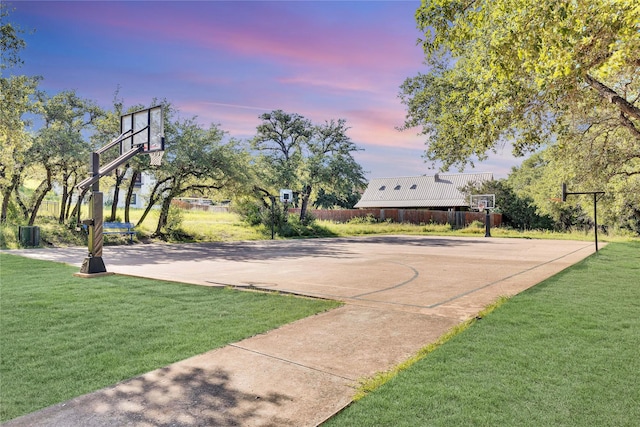 view of sport court featuring community basketball court, a lawn, and fence