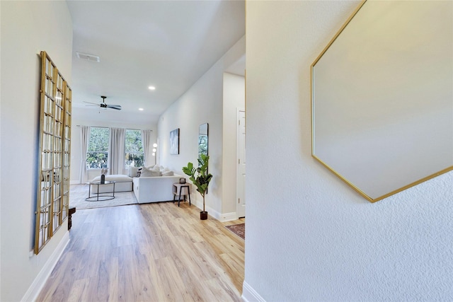 corridor with french doors, wood finished floors, visible vents, and baseboards