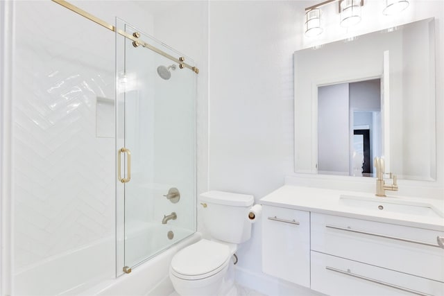 bathroom featuring toilet, combined bath / shower with glass door, and vanity