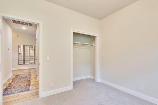 unfurnished bedroom with a closet, carpet, visible vents, and baseboards